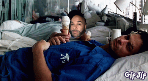 A Man Laying In A Hospital Bed Holding A Cone Of Ice Cream GIF