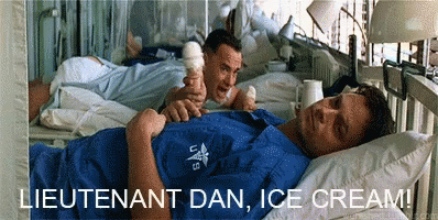 A Man Laying In A Hospital Bed Holding An Ice Cream Cone With The Words Lieutenant Dan Ice Cream Below Him GIF