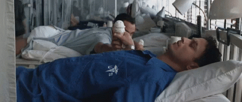 A Man Laying In A Hospital Bed With A U.s. Army Shirt On GIF