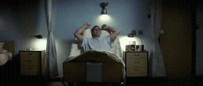 A Man Laying In A Hospital Bed With His Arms Outstretched GIF