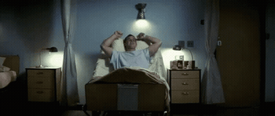 A Man Laying In A Hospital Bed With His Arms Outstretched GIF