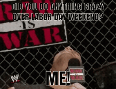 A Man Laying In Front Of A Sign That Says ' Did You Do Anything Crazy Over Labor Day Weekend ? Me ! ' GIF