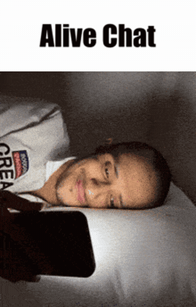 A Man Laying On A Bed Looking At A Cell Phone With The Words " Alive Chat " Above Him GIF