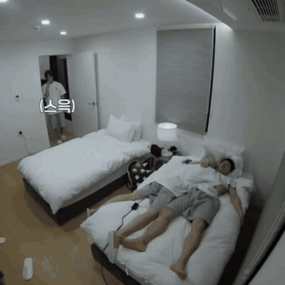 A Man Laying On A Bed Next To Another Man With Chinese Writing On It GIF