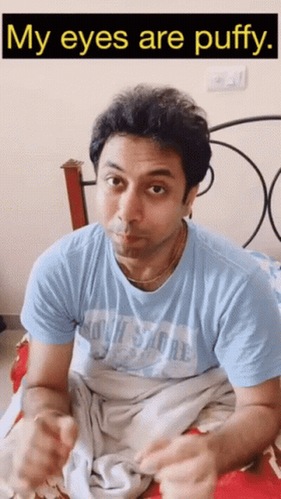 A Man Laying On A Bed With The Words " My Eyes Are Puffy " Below Him GIF