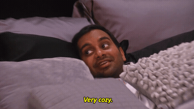 A Man Laying On A Bed With The Words " Very Cozy " Above Him GIF