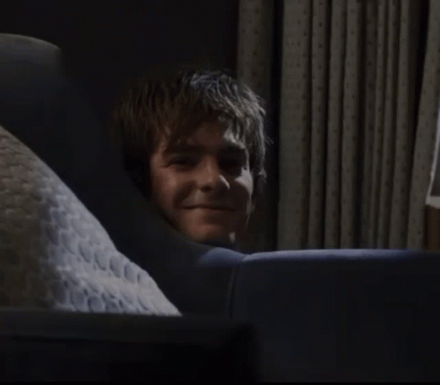 A Man Laying On A Couch With A Pillow That Says ' N.c.c. ' On It GIF