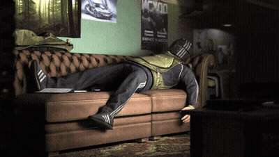 A Man Laying On A Couch With A Poster That Says Mcx00 On The Wall Behind Him GIF