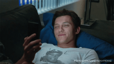 A Man Laying On A Couch With His Eyes Closed Looking At His Phone With The Hashtag #Spidermannowwayhome GIF