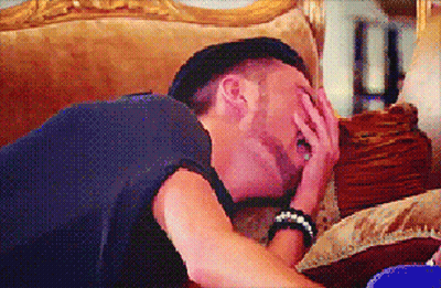 A Man Laying On A Couch With His Hand On His Face GIF