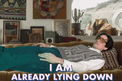 A Man Laying On A Couch With The Words " I Am Already Lying Down " GIF