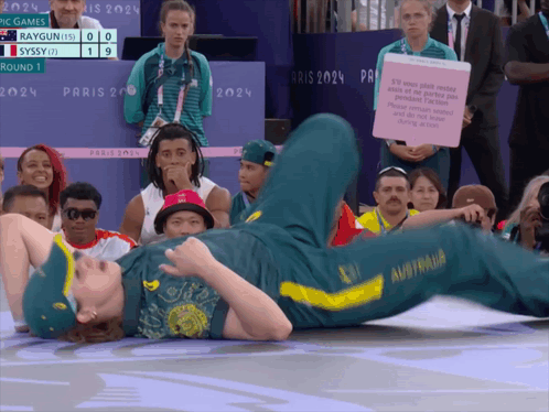 A Man Laying On His Back With A Sign That Says Australia On It GIF