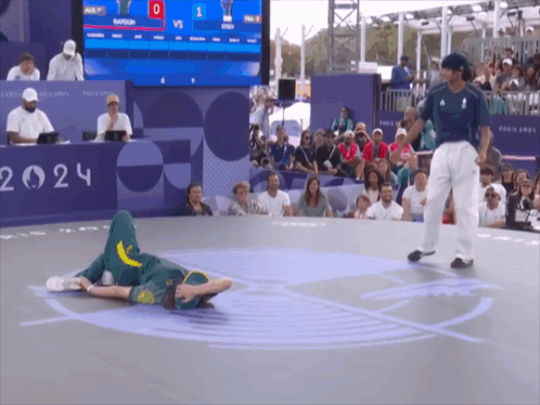 A Man Laying On The Floor In Front Of A Sign That Says 2024 GIF