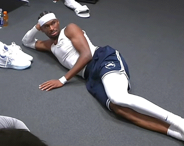 A Man Laying On The Floor With A Headband On GIF