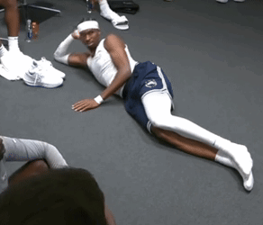 A Man Laying On The Floor With His Legs Crossed And A Headband On His Head GIF