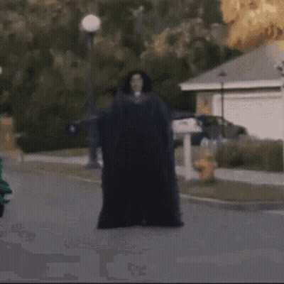 A Man Laying On The Ground In Front Of A House GIF
