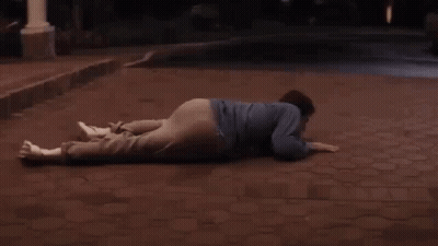 A Man Laying On The Ground In Front Of A White Car With The Word End Written On The Bottom GIF