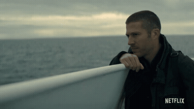 A Man Leaning Against A Railing On A Boat With Netflix Written On The Bottom GIF