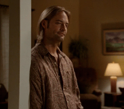 A Man Leaning Against A Wall In A Living Room GIF