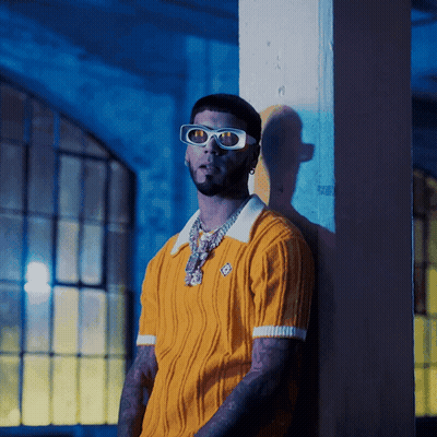 A Man Leaning Against A Wall Wearing Sunglasses GIF