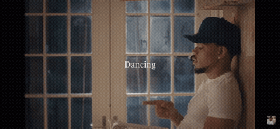A Man Leaning Against A Wall With The Word Dancing On The Bottom GIF