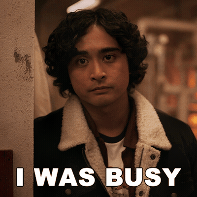 A Man Leaning Against A Wall With The Words I Was Busy Behind Him GIF