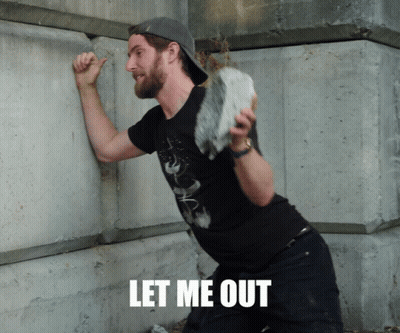 A Man Leaning Against A Wall With The Words Let Me Out Written On The Bottom GIF