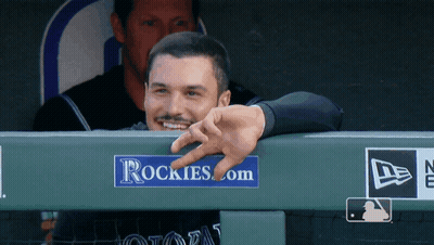 A Man Leaning Over A Rockies.com Sign GIF