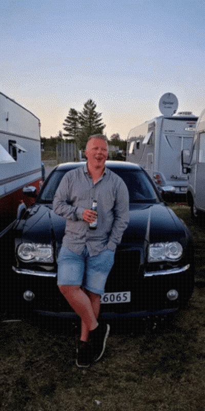A Man Leans Against A Black Car With A License Plate That Says ' 6060 ' GIF