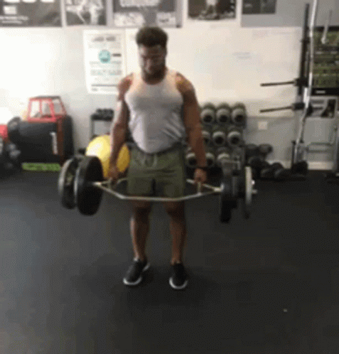 A Man Lifting A Barbell In A Gym GIF