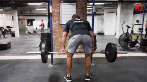 A Man Lifting A Barbell In A Gym Wearing A Shirt That Says " Athlete " GIF