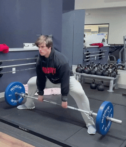 A Man Lifting A Barbell In A Gym With A Rogue Logo On The Barbell GIF