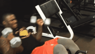 A Man Lifting Dumbbells In A Gym With The Words Mo Usman Is Here To Below Him GIF