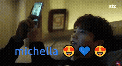 A Man Looking At A Cell Phone With The Name Michella On The Bottom Right GIF