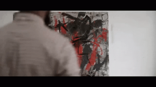 A Man Looking At A Painting On A Wall GIF