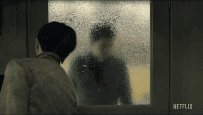 A Man Looking Out A Window With A Netflix Logo On The Bottom Right GIF