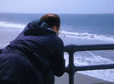A Man Looking Out Over The Ocean From A Pier GIF
