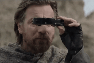 A Man Looking Through A Pair Of Binoculars With A Beard GIF