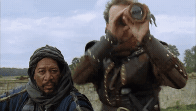 A Man Looking Through Binoculars With Another Man Behind Him GIF