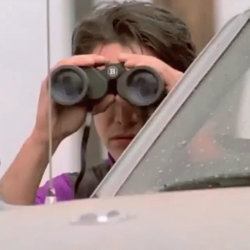 A Man Looking Through Binoculars With The Letter B On Them GIF