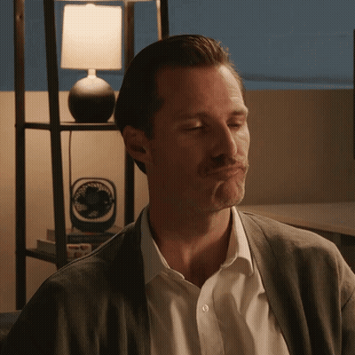 A Man Making A Face In Front Of A Lamp And A Fan GIF