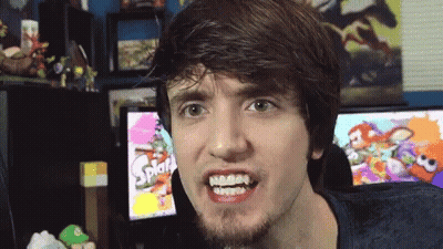 A Man Making A Funny Face In Front Of A Screen That Says Splat GIF