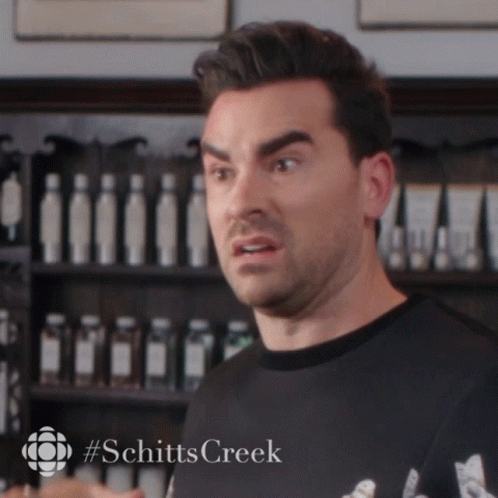A Man Making A Funny Face With #Schitts Creek Written On The Bottom Right GIF