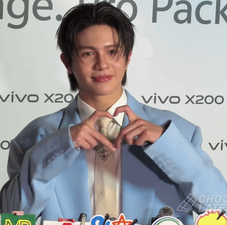 A Man Making A Heart Shape With His Hands In Front Of A Vivo X200 Sign GIF