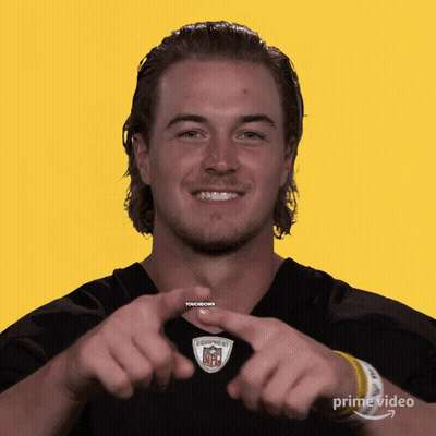 A Man Making A Heart Shape With His Hands In Front Of A Yellow Background GIF