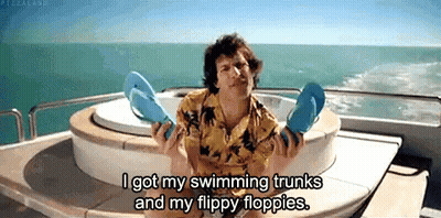 A Man On A Boat Holding Flip Flops And Saying I Got My Swimming Trunks And My Flippy Floppies . GIF