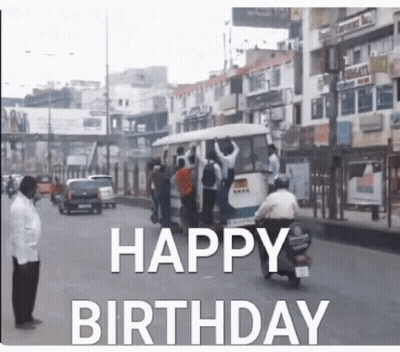 A Man On A Motorcycle Is Driving Down A Street With The Words Happy Birthday Written On It GIF