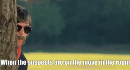 A Man Peeking Out From Behind A Tree With A Caption That Says When The Suspects Are On The Move In The Room GIF