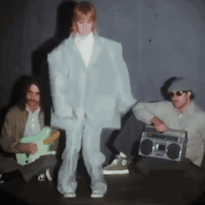 A Man Playing A Guitar And A Man Holding A Boom Box GIF