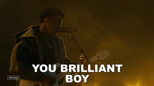 A Man Playing A Guitar And Singing Into A Microphone With The Words You Brilliant Boy Above Him GIF